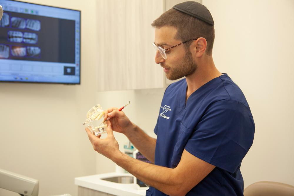 dr eli shteingart looking at impression | dental implants teaneck nj